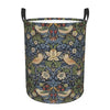 A vintage floral laundry hamper with a dark blue and green pattern featuring birds and foliage.