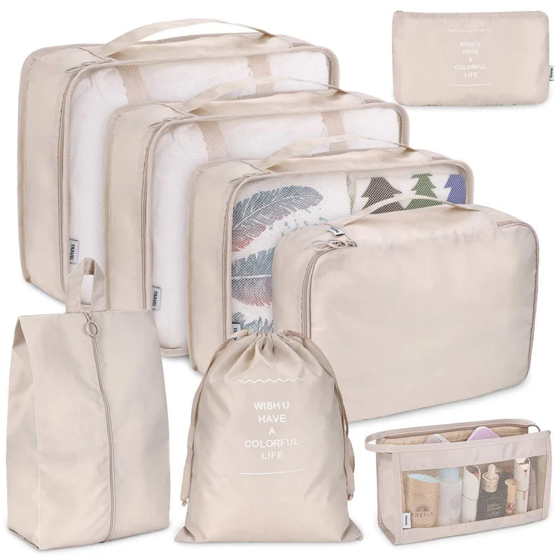 A set of seven beige and white folding storage bags for travel organization.