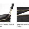 A black nylon crossbody bag featuring a gold zipper and an adjustable strap.
