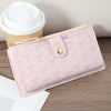A pink folding multi-card wallet with a decorative bow detail is shown next to a paper cup.
