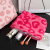 A bright pink plush storage bag with a heart pattern is shown next to cosmetic applicators.