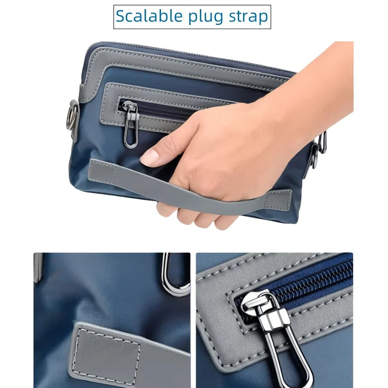 A hand is holding a navy blue crossbody bag with a gray strap, showing the adjustable plug strap feature.