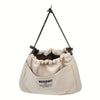 A beige drawstring canvas storage organizer bag with black cord handles.