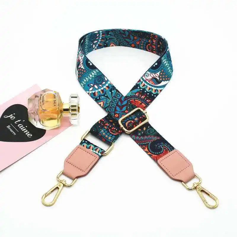 A patterned teal and orange adjustable crossbody strap for a handbag.