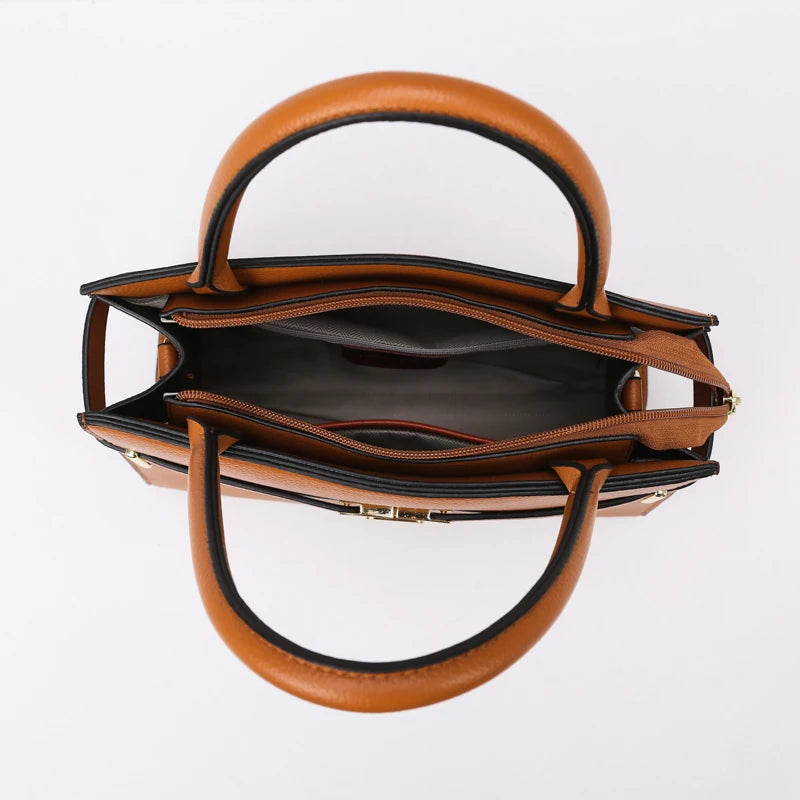A tan leather handbag with a curved handle and flap, shown against a white background.