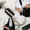 A black foldable mini keychain tote bag is shown attached to a silver chain, held by a person.