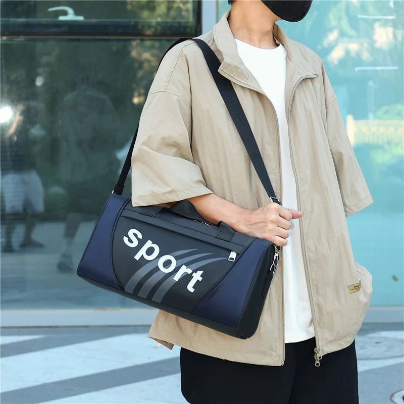 A person wearing a beige jacket is holding a navy blue and gray sports backpack.