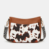 A brown and white cow print PU leather shoulder crossbody bag with gold hardware.