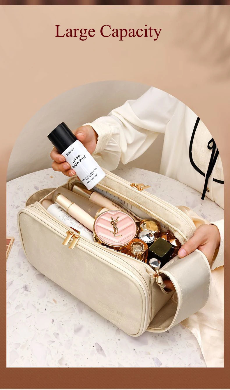 A hand holds a beige PU leather travel makeup organizer with double zippers, showing various cosmetic bottles inside.
