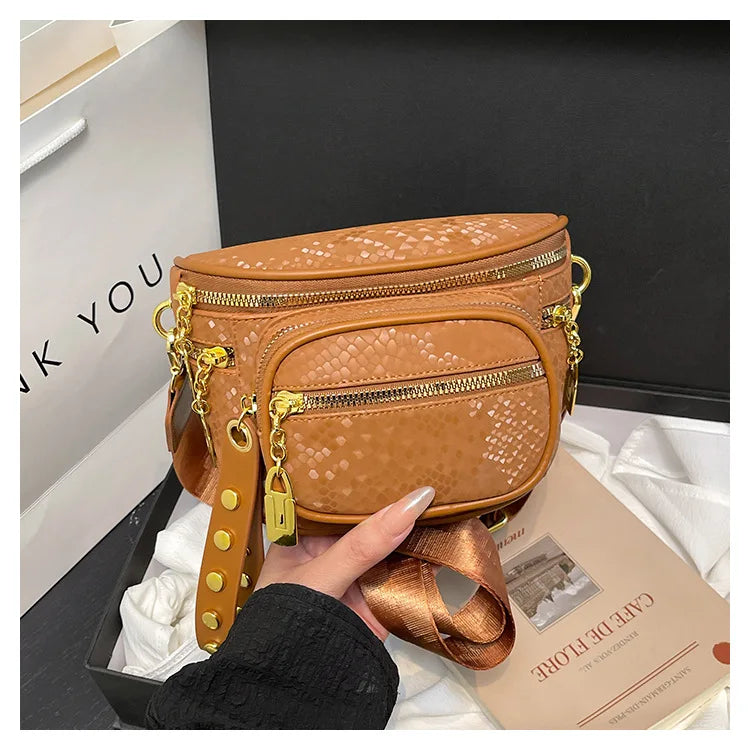 A brown women's rivet waist bag crossbody fanny pack with gold hardware shown against a dark background.