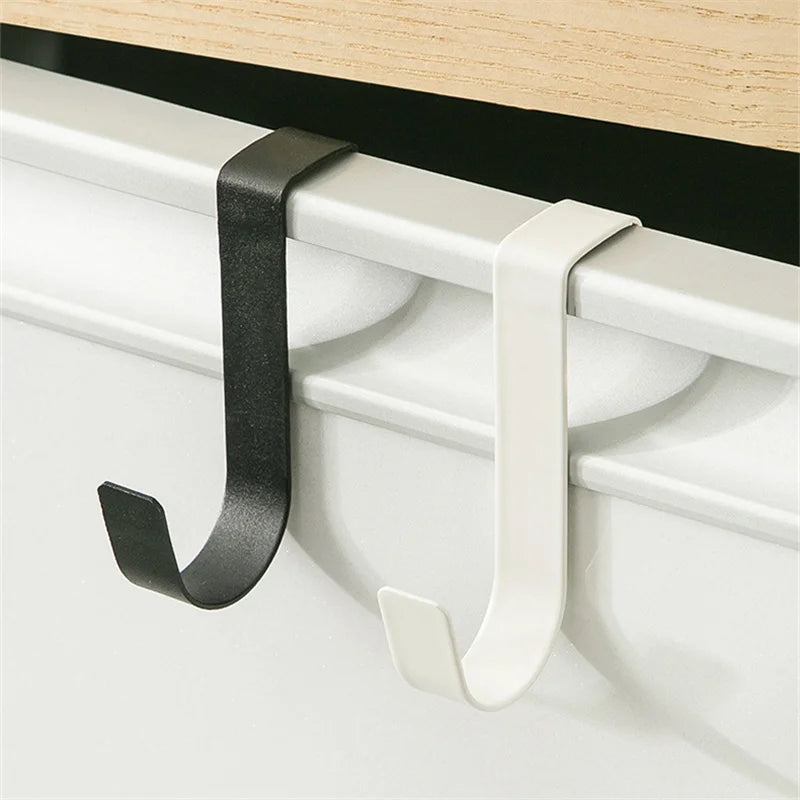 A black and white heavy duty hook rack installed on a cabinet door frame.