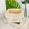 Light pink fabric storage basket with a scalloped edge and yellow heart details resting on a wooden box.