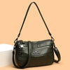 Bolso cruz de cuero verde oscuro y moderno para mujer con detalle de cadena dorada.
