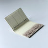 A light cream leather passport holder with a crocodile pattern and custom initials, shown open.