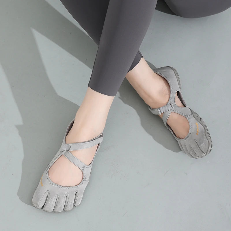 Gray women's barefoot five-toe shoes with an adjustable strap worn on a foot.