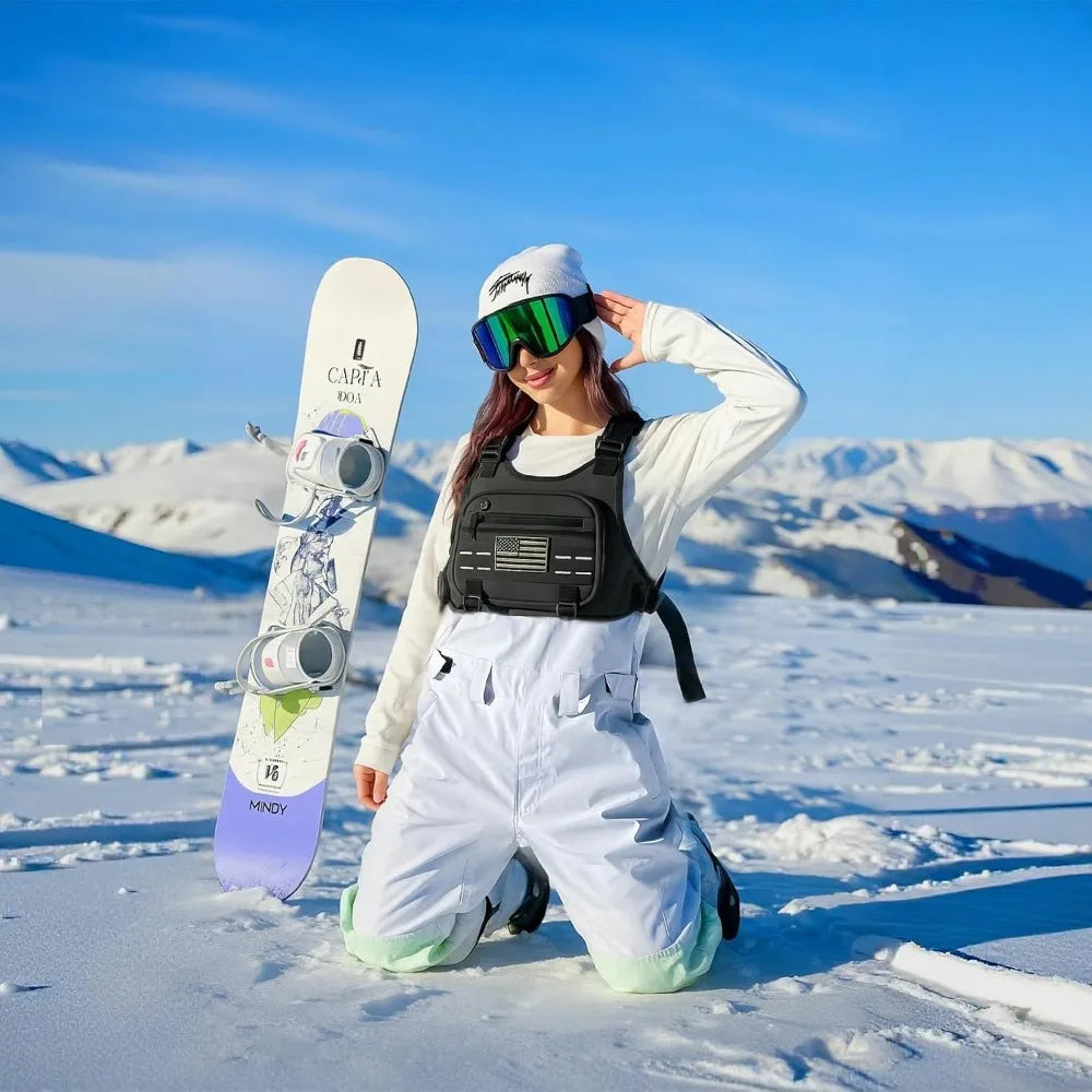 Une femme portant une veste et un pantalon blancs avec un sac à dos noir, vêtue de lunettes de soleil, se tient dans un paysa