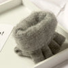 Nahaufnahme eines grauen Strickfingerless-Handschuhs in einer weißen Box.