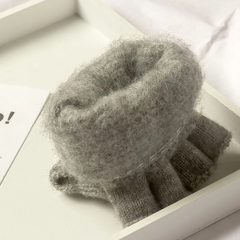 Nahaufnahme eines grauen Strickfingerless-Handschuhs in einer weißen Box.