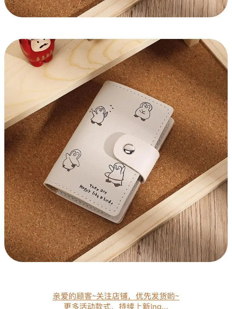 Helles beiges Cartoon-Katze-ID-Karten-Wallet auf einer Holzoberfläche mit natürlichem Hintergrund.