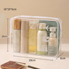 Clear PVC toiletry bag containing various skincare and cosmetic bottles and tubes