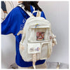 A white Korean style backpack with a blue shirt worn by a person.