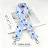 A light blue and pink patterned nylon shoulder strap for bags and purses displayed next to a white box.