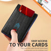 A hand holds a black carbon fiber wallet with a red card slot, demonstrating easy access to cards.