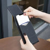 A hand is holding a black PU leather phone waist pouch with a belt clip, displaying a smartphone.