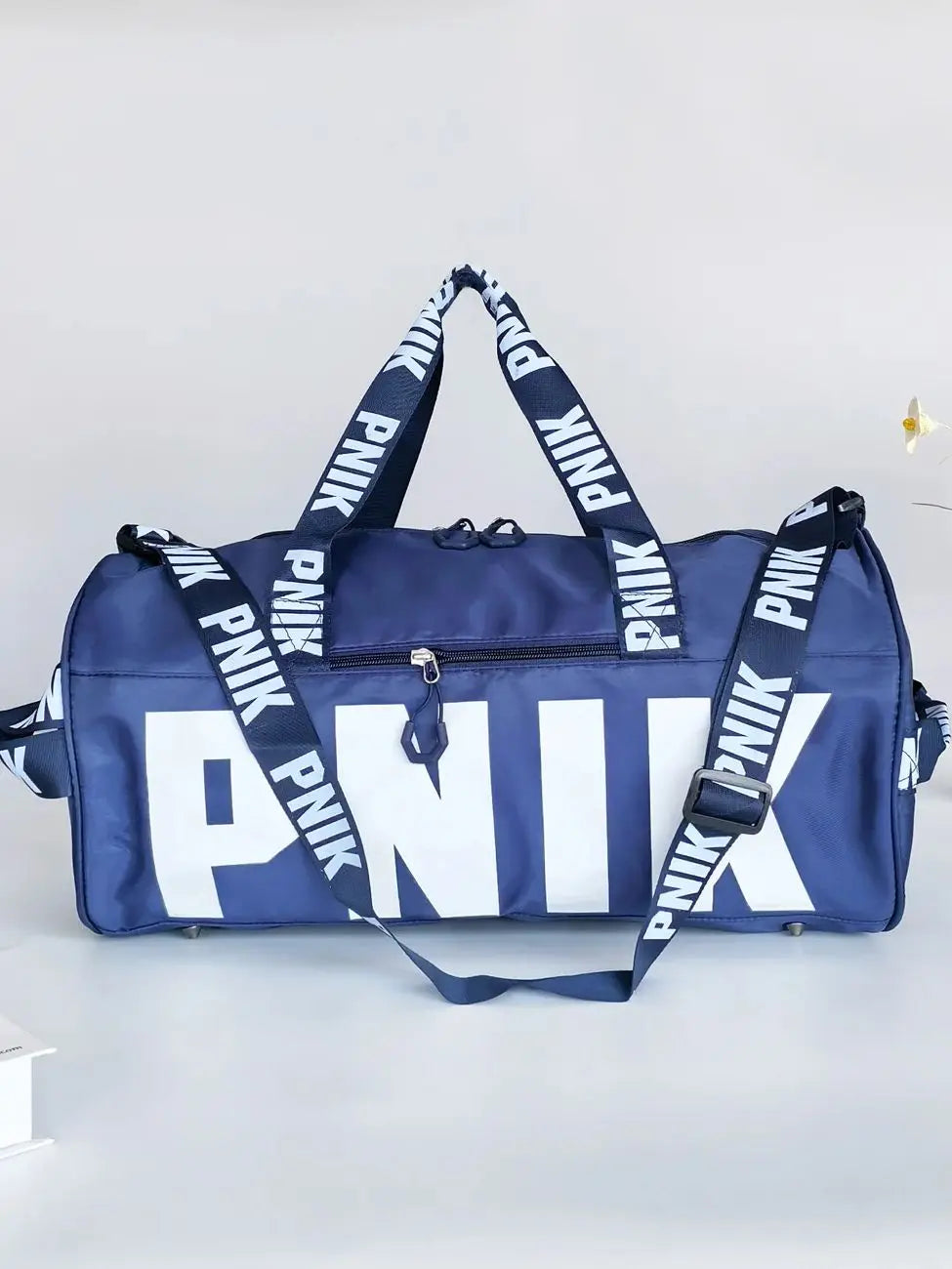 A navy blue Nike backpack with white lettering and black straps is shown against a light gray background.