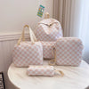 A light pink and white checkerboard multi-pocket backpack with tan straps resting on a white marble surface.