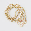 A stack of gold and white leather chain straps for an adjustable crossbody purse.