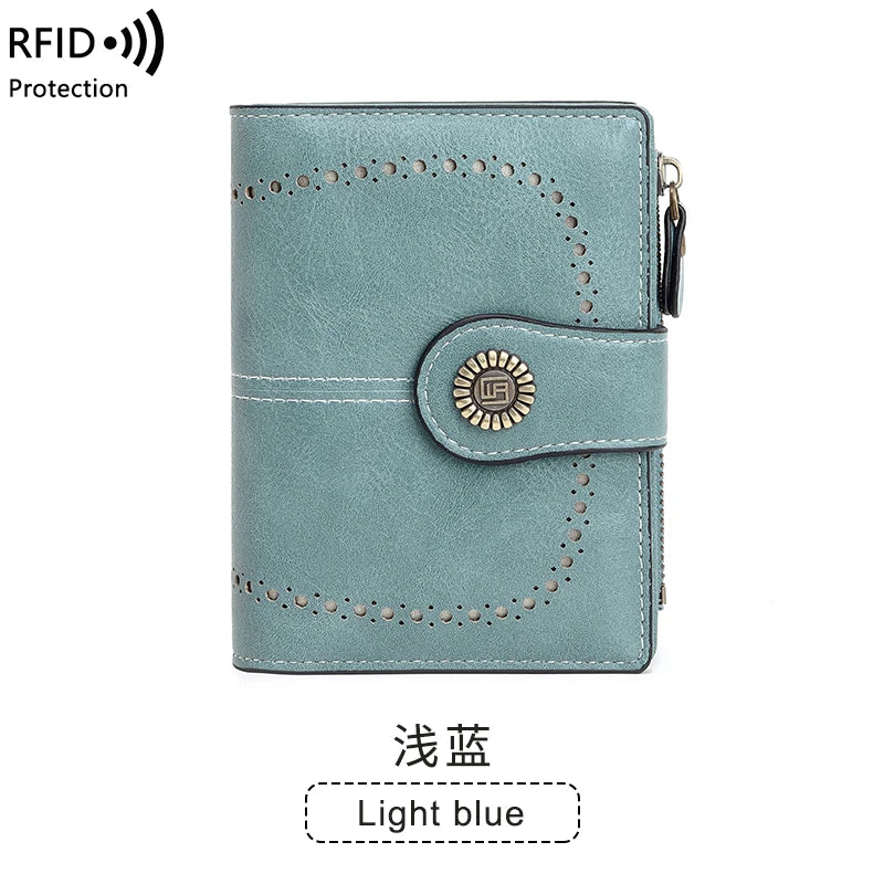 A light blue multi-fold wallet with decorative stitching and a gold-colored emblem.