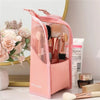 Pink foldable makeup brush storage case with brushes and a brush lying nearby