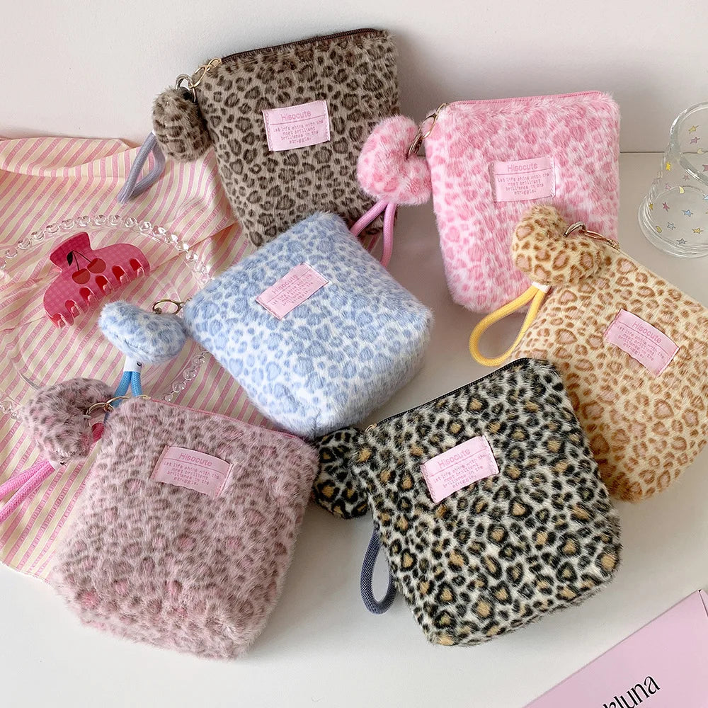 A collection of leopard print and pink fuzzy makeup bags for skincare organization.