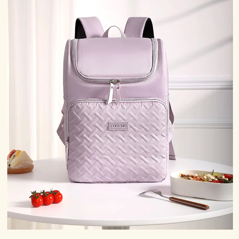 A light purple insulated picnic cooler backpack with black accents sitting on a white table.