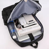Offener schwarzer Rucksack mit weißem Laptop, Maus und anderen Elektronikzubehörteilen darin.