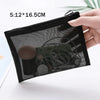 A hand holds a black mesh cosmetic storage pouch with a zipper, showing the clear netting and contents.