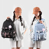 Two girls wearing light gray dresses holding Capybara Print Canvas backpacks