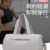 A light beige gym duffel bag is shown next to a woman wearing athletic wear, highlighting its design for sports and travel.