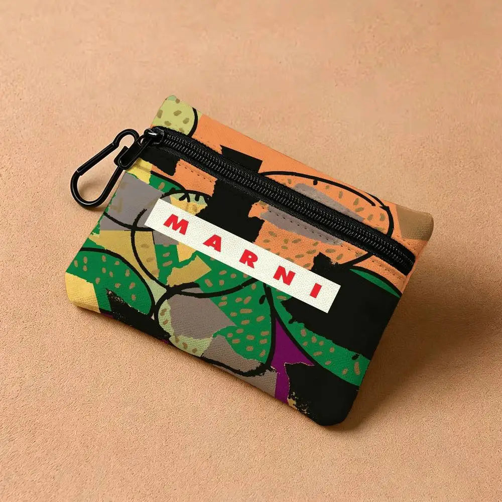 A floral print mini coin purse with a black zipper and carabiner clip resting on a beige surface.