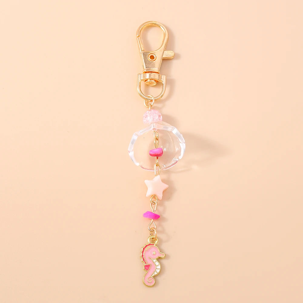 Gold-toned starfish keychain with pink and clear pearl accents