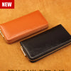 Two genuine leather zipper wallets, one orange and one black, are displayed on a brown textured surface.