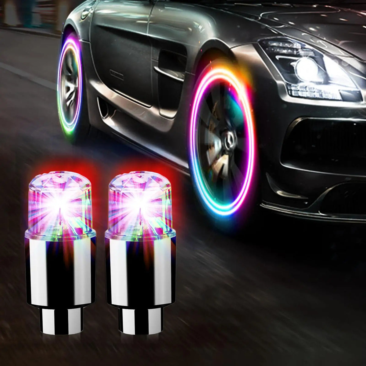 A pair of bright LED tire valve stem lights illuminating a dark car wheel.