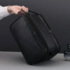 A hand is holding a black PU leather travel toiletry bag with organizer pockets.