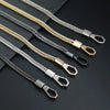 Multiple metal bag chain straps in silver and gold tones laid out on a dark surface.