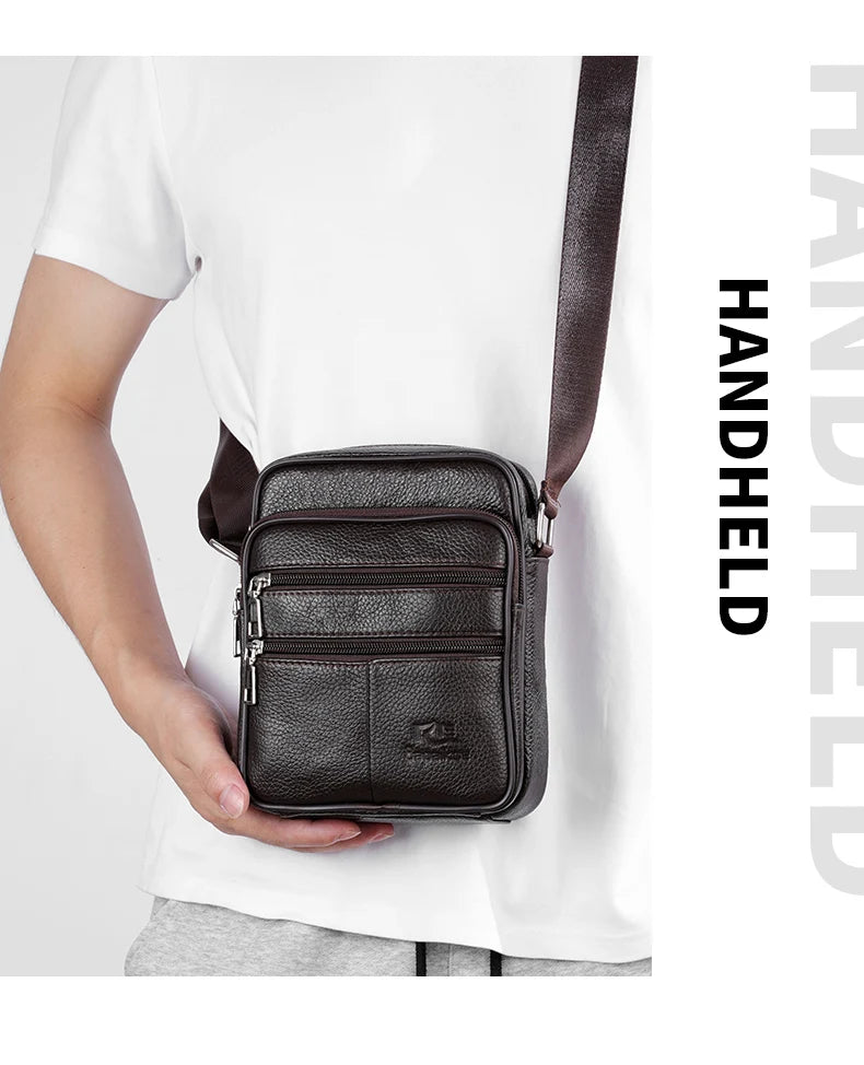 A dark brown vintage leather messenger bag with a black strap is shown being held by a person wearing a white t-shirt.