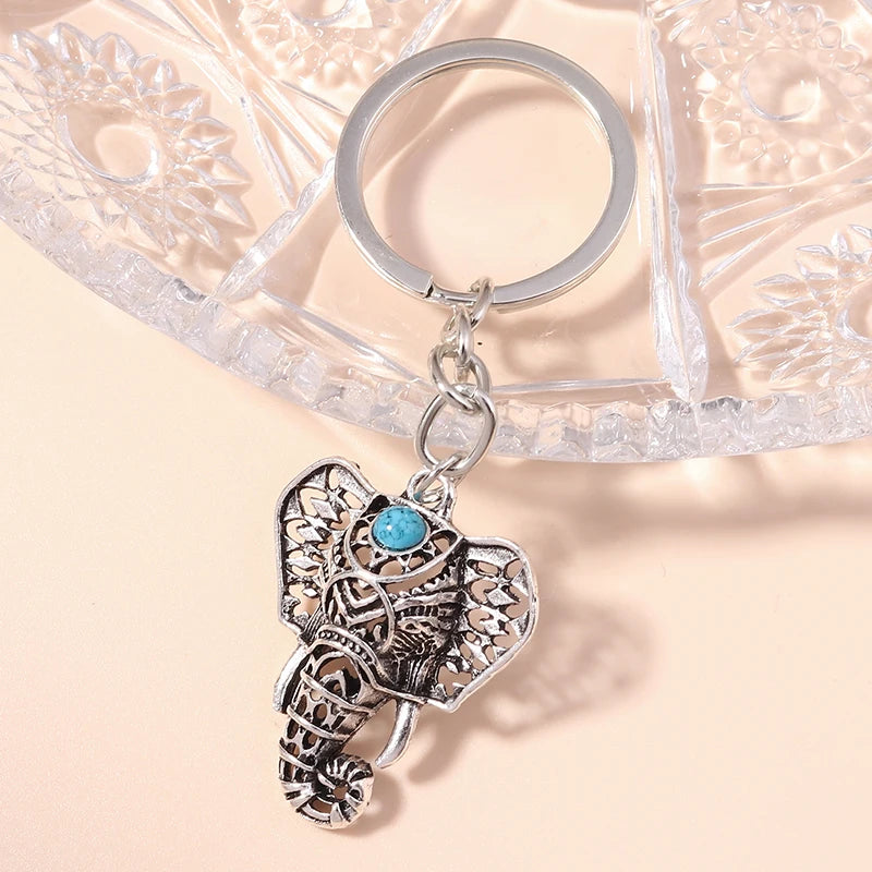 Silver gothic steampunk heart keychain featuring an ornate design and a turquoise sun eye pendant