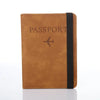 A brown leather passport organizer with a black strap and an airplane icon embossed on the cover.