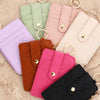 A collection of pastel pink, green, purple, and orange PU leather card holder wallets with gold rings.