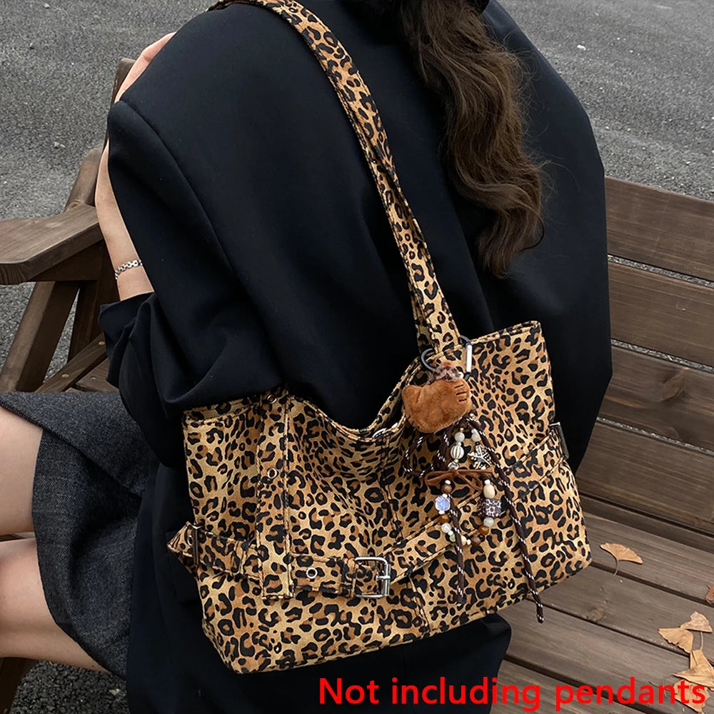 A person is holding a leopard print casual tote bag with brown leather accents and a black coat.